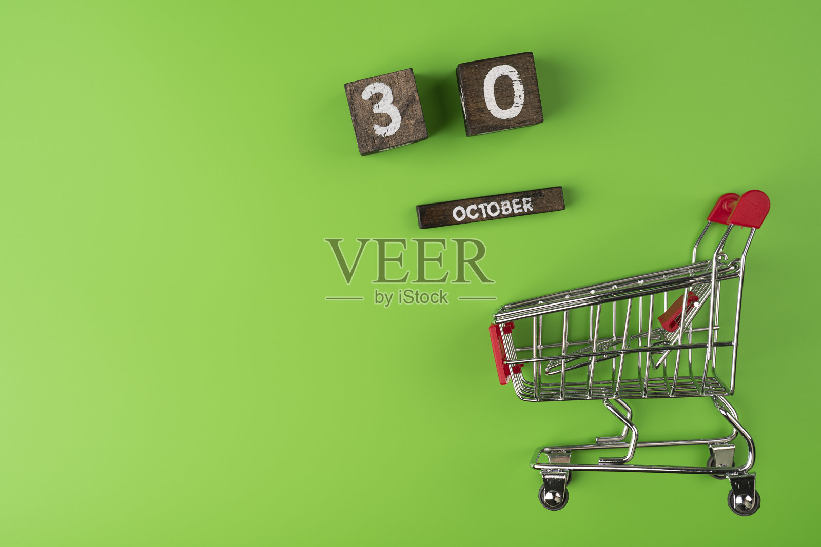 小型超市购物车购物孤立在绿色背景上。照片摄影图片