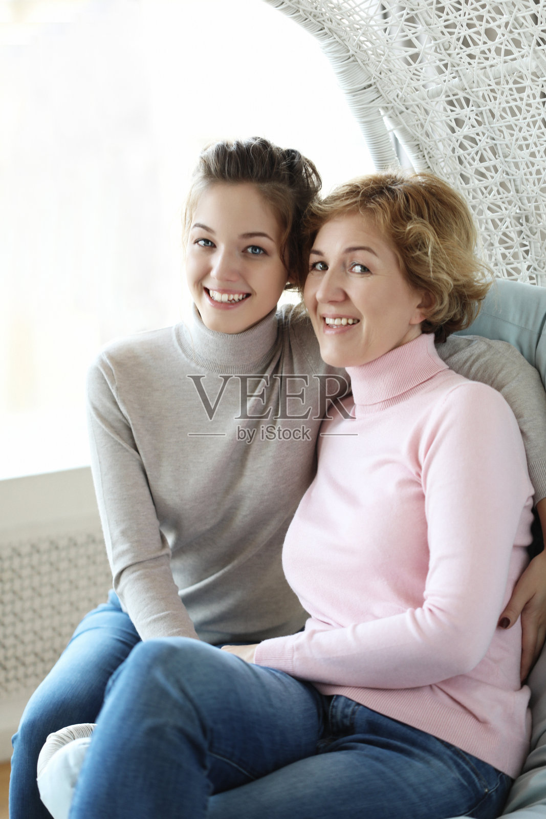 美丽的老年妈妈和她已成年的女儿拥抱在一起,看着镜头微笑着照片摄影图片