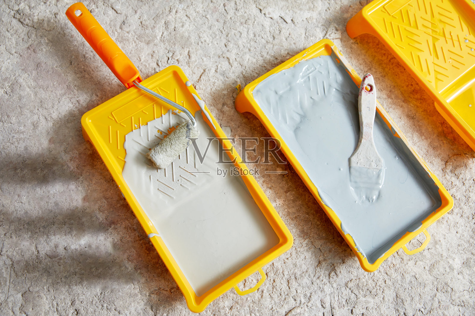 近距离观察油漆托盘填充灰色油漆。油漆工和重新装饰的工具照片摄影图片