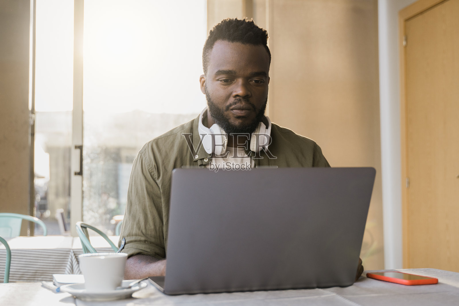 商业非洲人使用电脑笔记本工作在酒吧餐厅-关注脸照片摄影图片