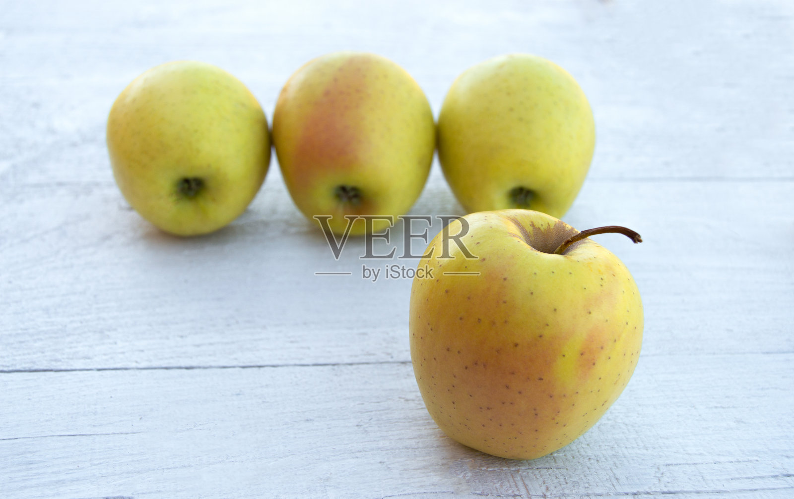 浅色背景上的金苹果。照片摄影图片