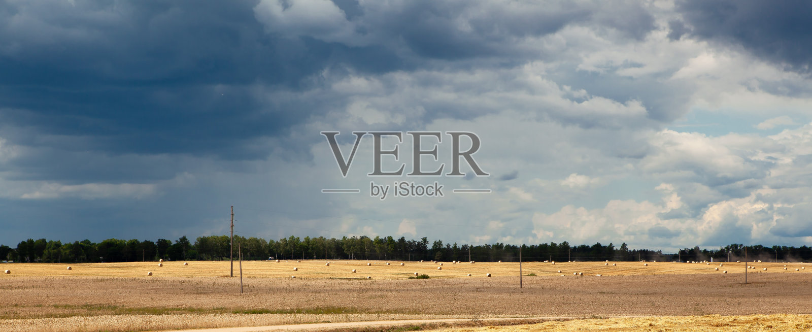 7月下雨前,一片收割过的麦田,映衬着狂风暴雨的天空。照片摄影图片