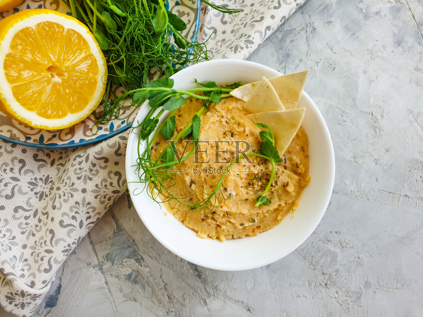 新鲜的鹰嘴豆泥,混凝土背景上的欧芹照片摄影图片