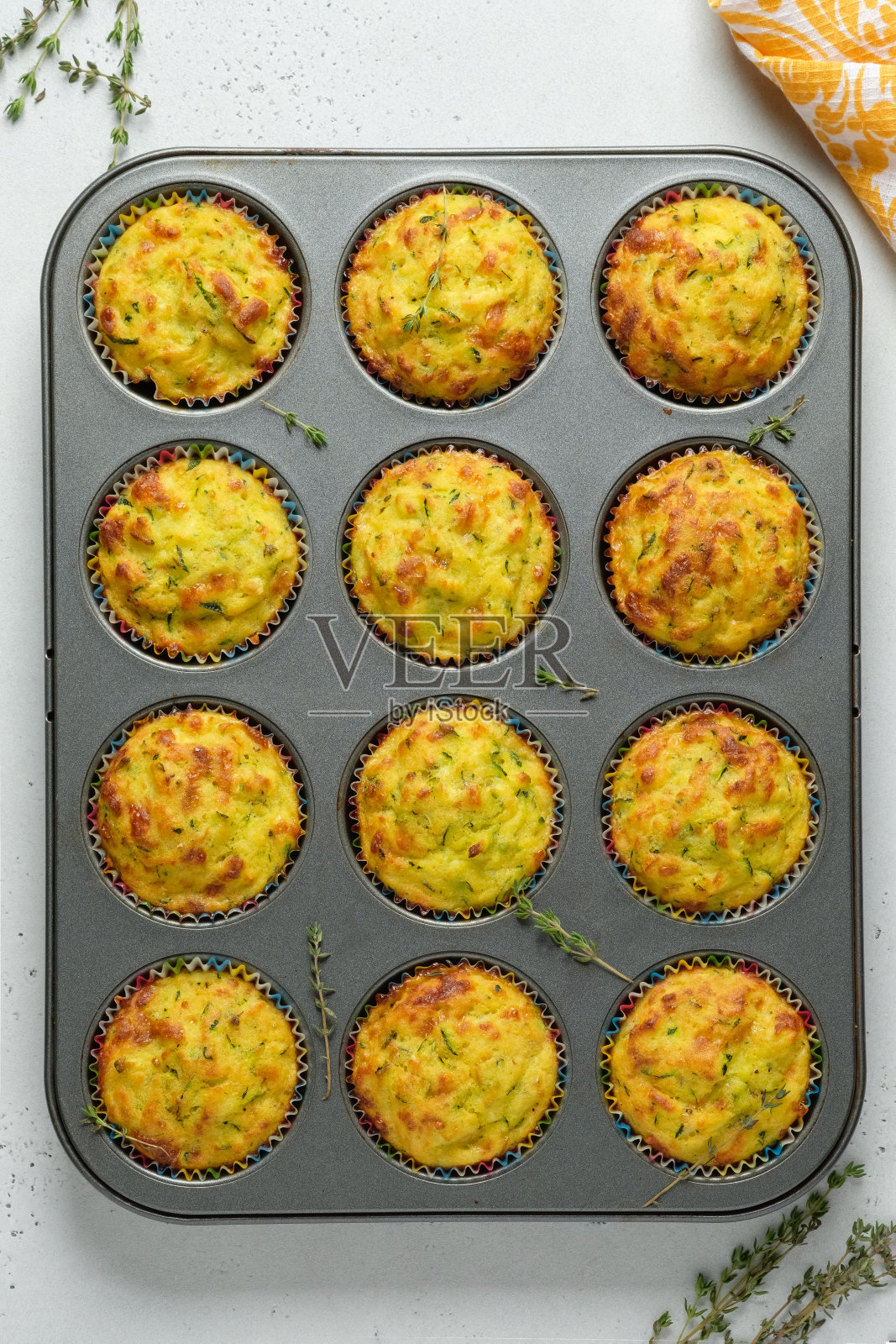 西葫芦松饼配奶酪和百里香,放在桌子上的烤盘里。从上往下看。照片摄影图片