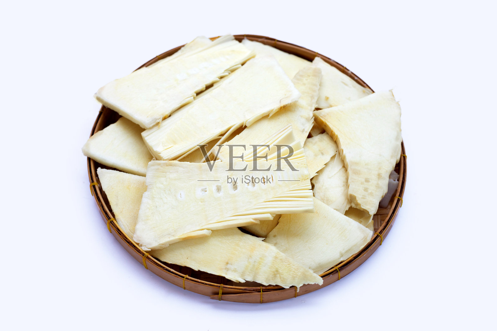 白底竹篮中生竹笋片。照片摄影图片