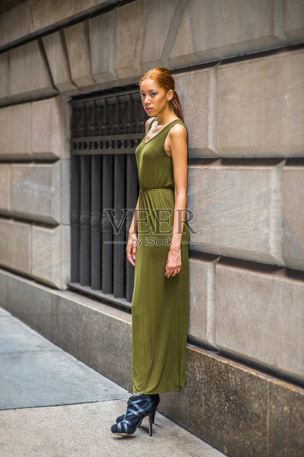 年轻女子站在纽约市的墙边,正在放松照片摄影图片