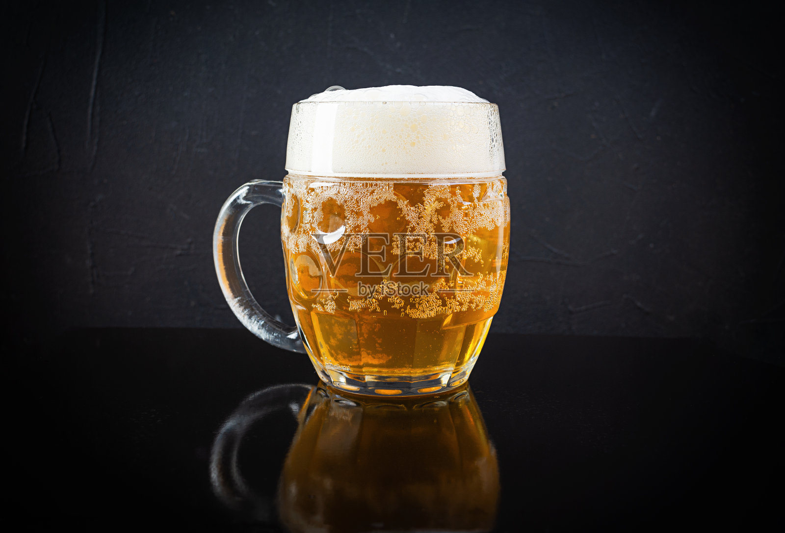 黑色背景下的一杯淡啤酒。工艺未过滤的啤酒照片摄影图片