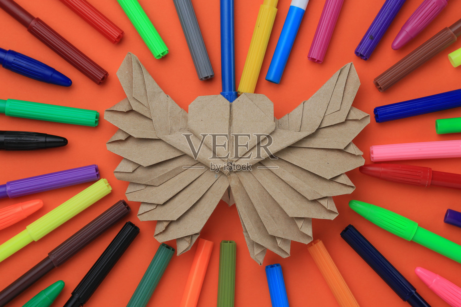 纸心脏模型。有选择性的重点。在模糊的背景上有很多彩色毡尖笔照片摄影图片