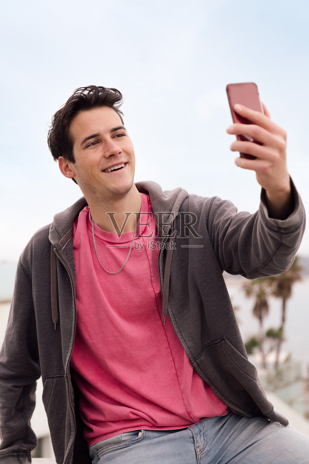 一名年轻人用智能手机自拍照片摄影图片