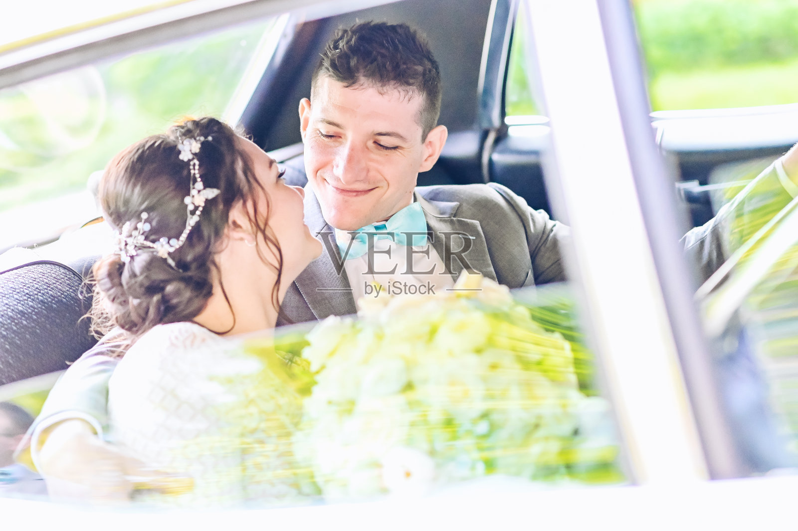 婚礼当天,新娘新郎在豪华轿车后座放松照片摄影图片