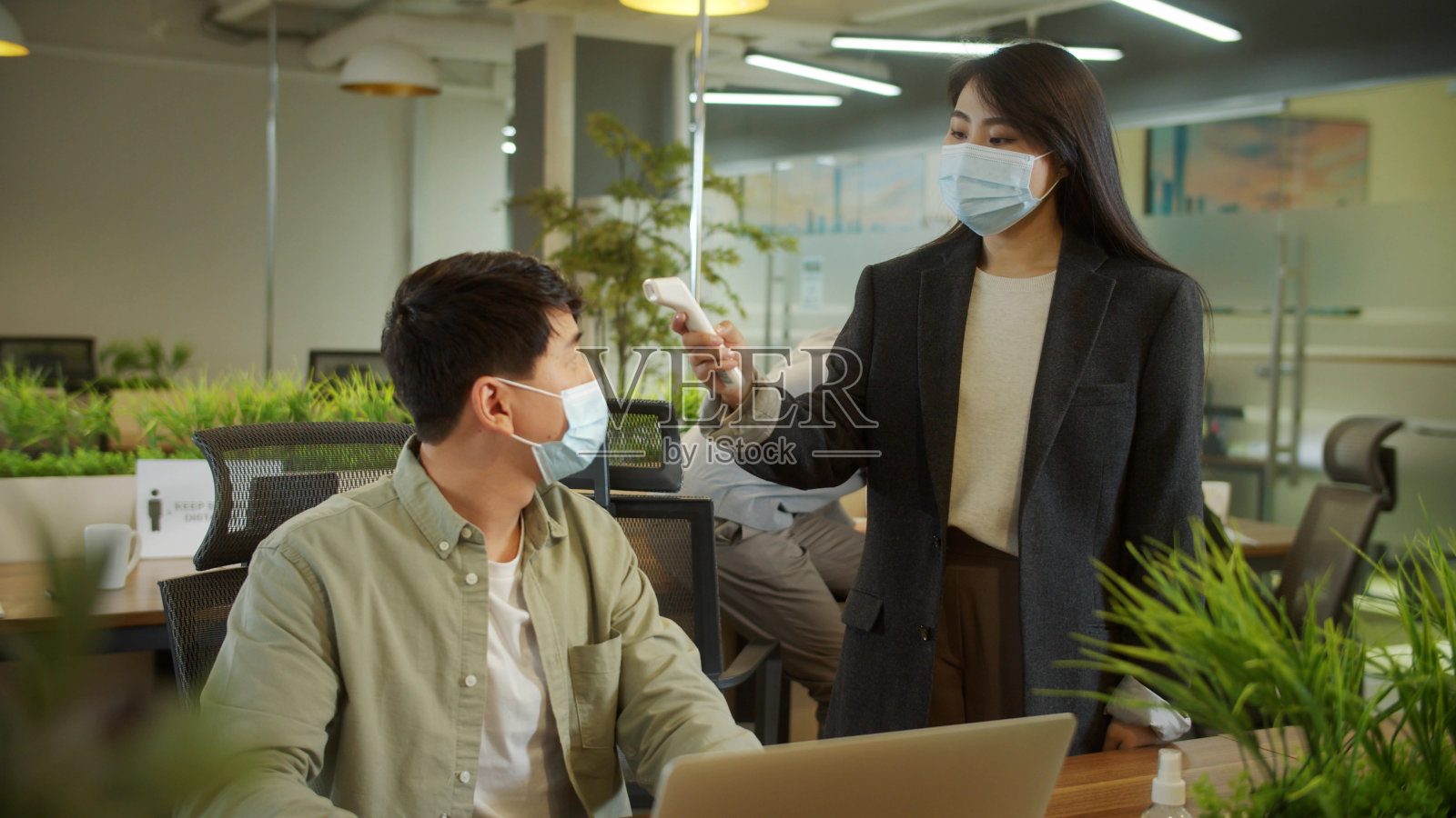 一位男士的同事正在测量体温照片摄影图片