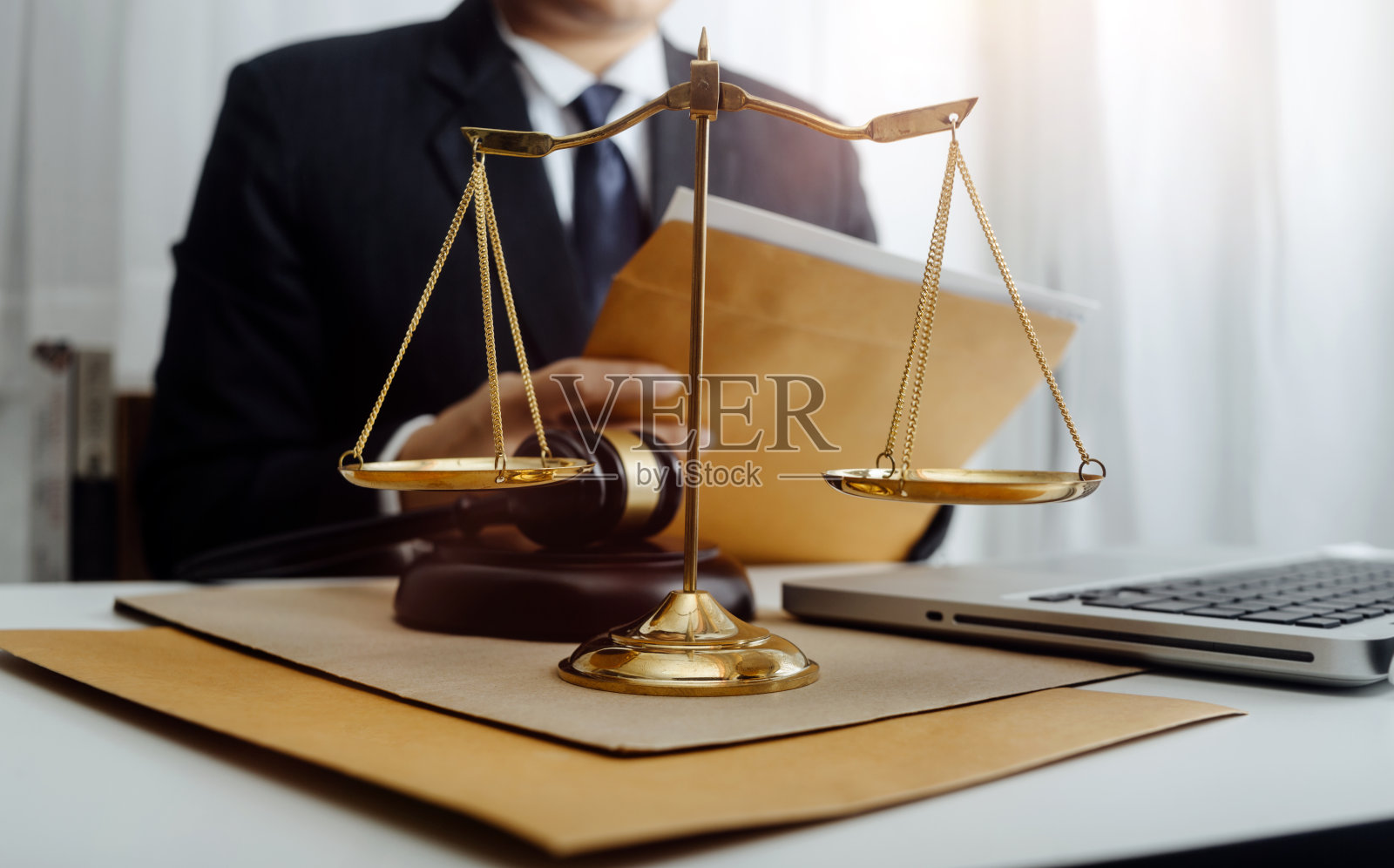 商务和律师在办公室桌上用黄铜秤讨论合同文件。法律、法律服务、法律咨询、司法和法律概念的画面具有电影纹理的效果照片摄影图片