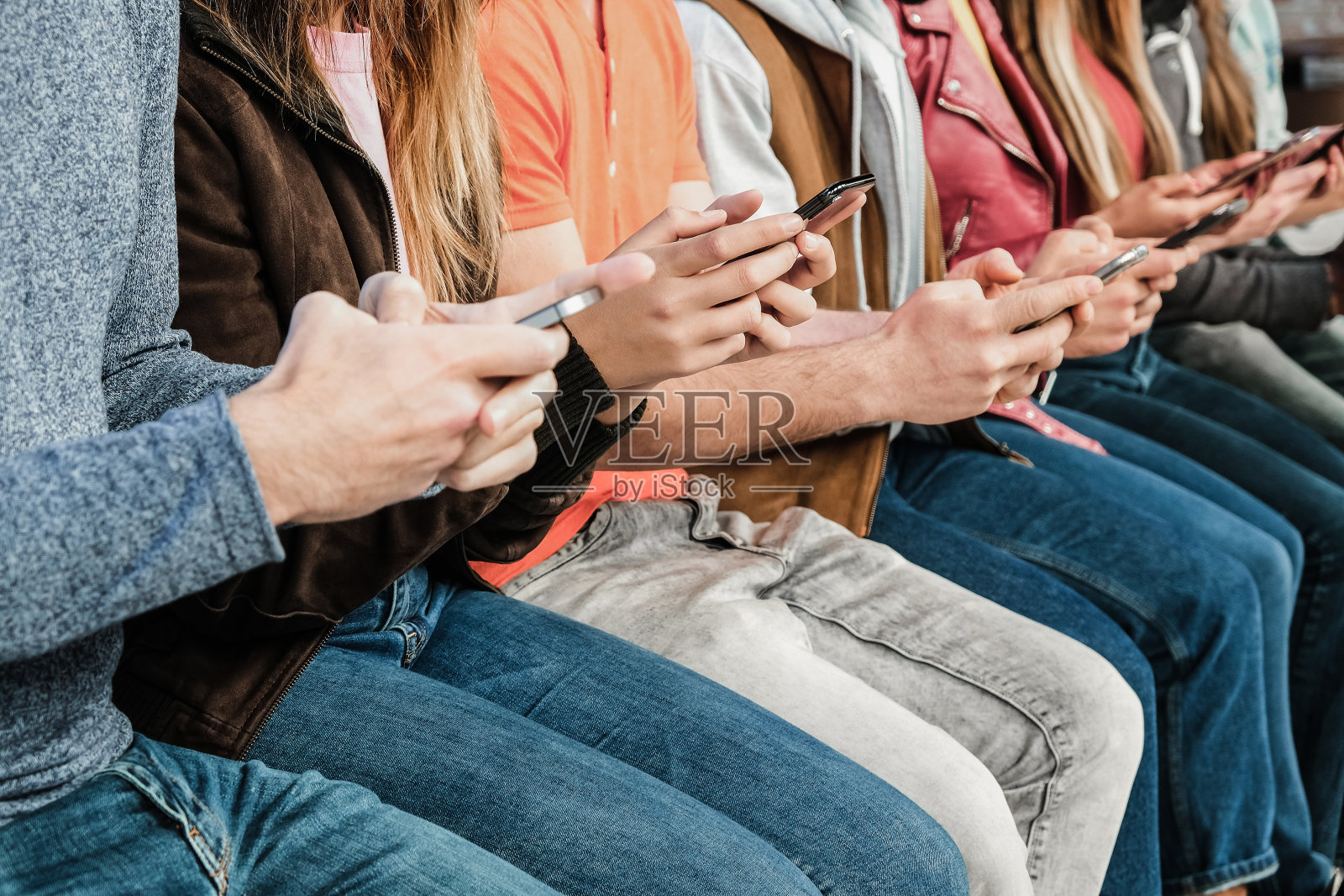 一群在城市户外使用手机的朋友-关注中心男人的手照片摄影图片