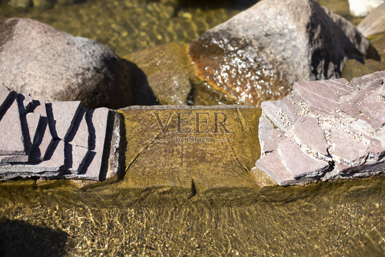 公园里石头间的小溪。照片摄影图片