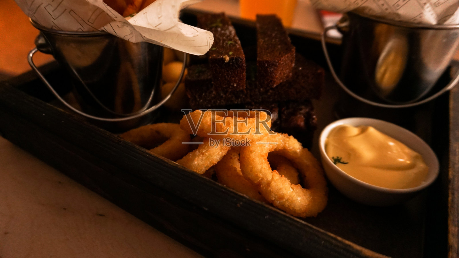 啤酒套小吃在木制托盘上。在小餐馆为朋友们准备点心照片摄影图片