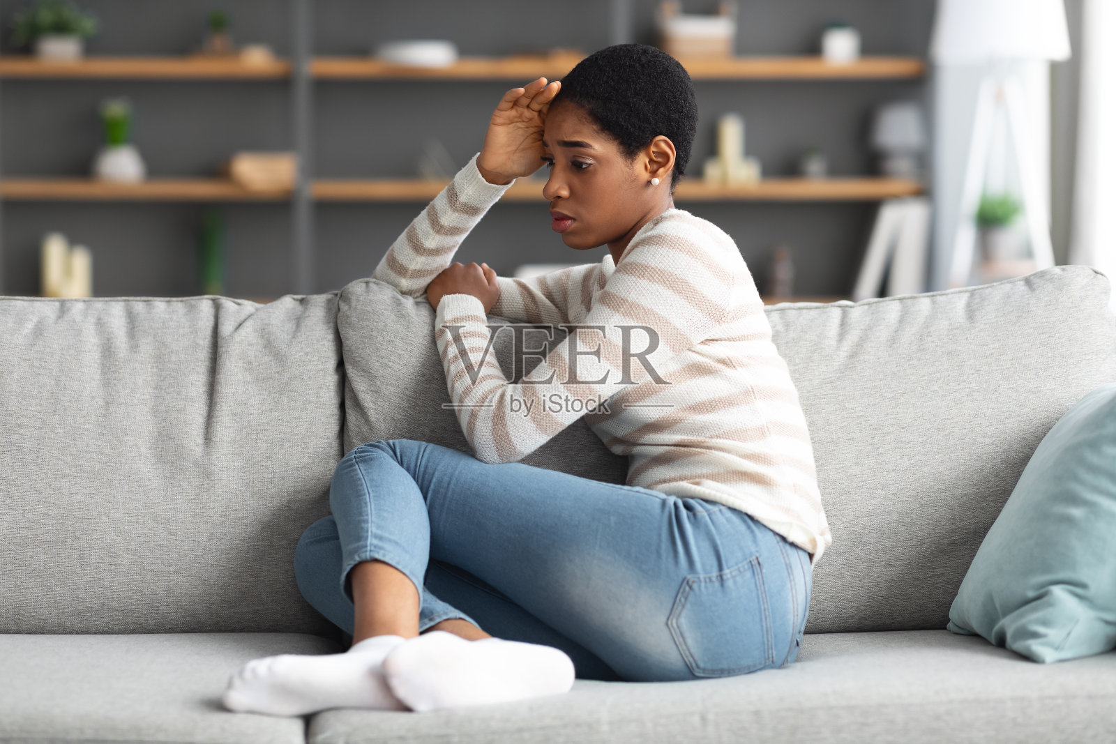 糟糕的一天:沮丧的非裔美国妇女坐在客厅的沙发上照片摄影图片