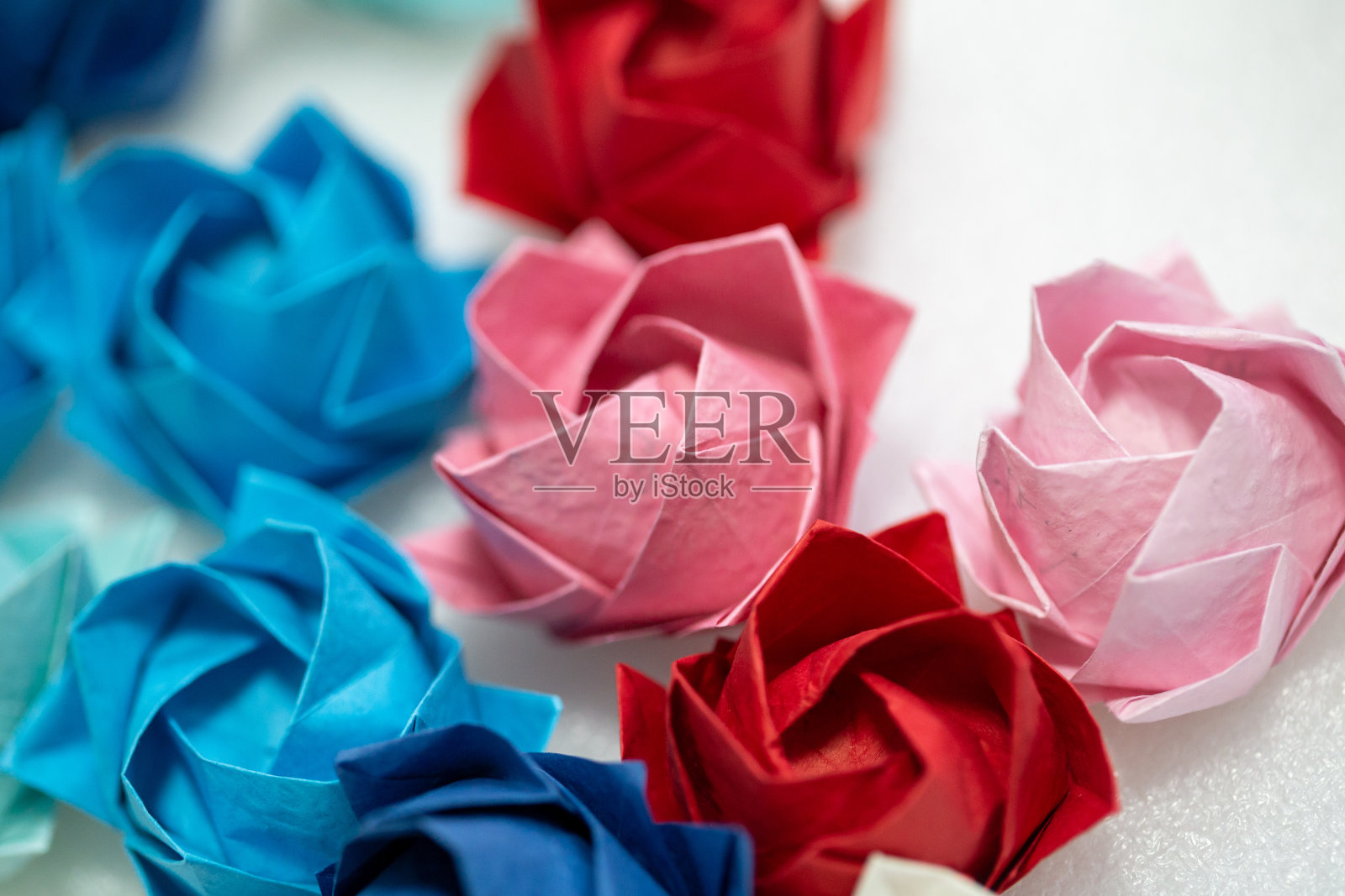 彩色纸玫瑰与白色背景照片摄影图片