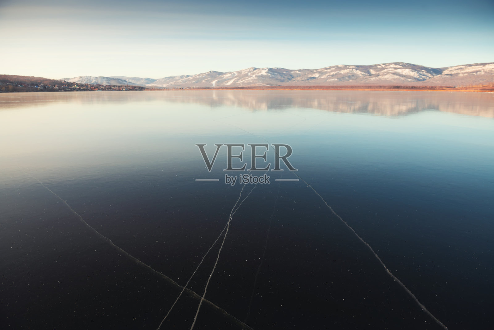 日出时结冰的湖面上的冰。照片摄影图片