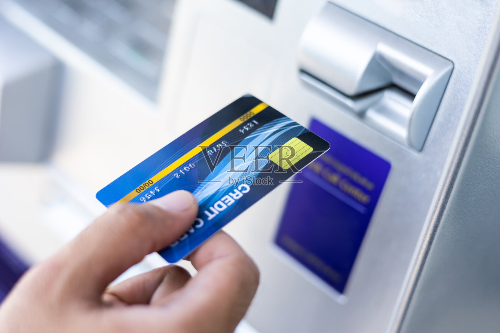 一名男子用信用卡从自动提款机取钱。一名男子将银行卡插入银行自动取款机。照片摄影图片