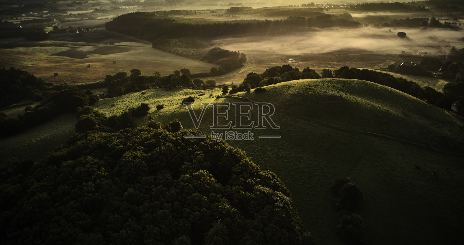 清晨的阳光照在山顶上照片摄影图片