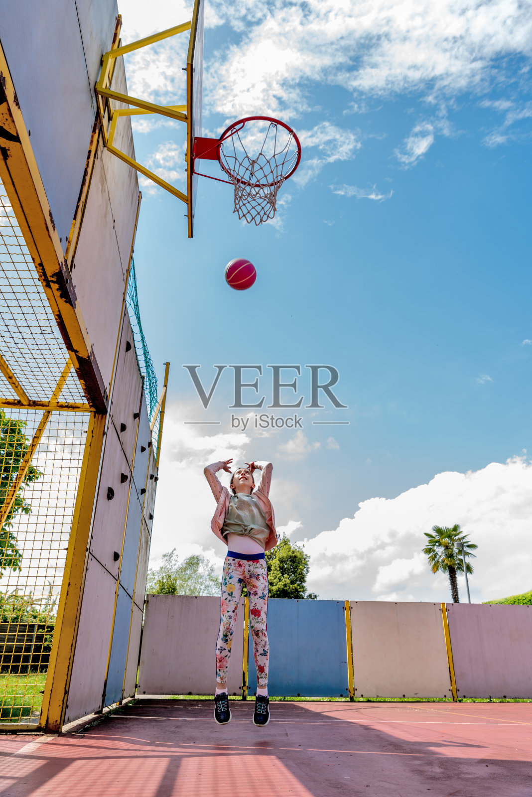 女孩独自在城市篮球场练习篮球照片摄影图片