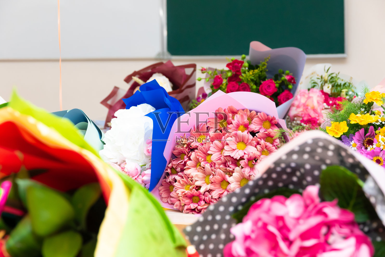 9月1日,在学校董事会的背景下,学校桌子上放着一束美丽明亮的鲜花。有选择性的重点照片摄影图片