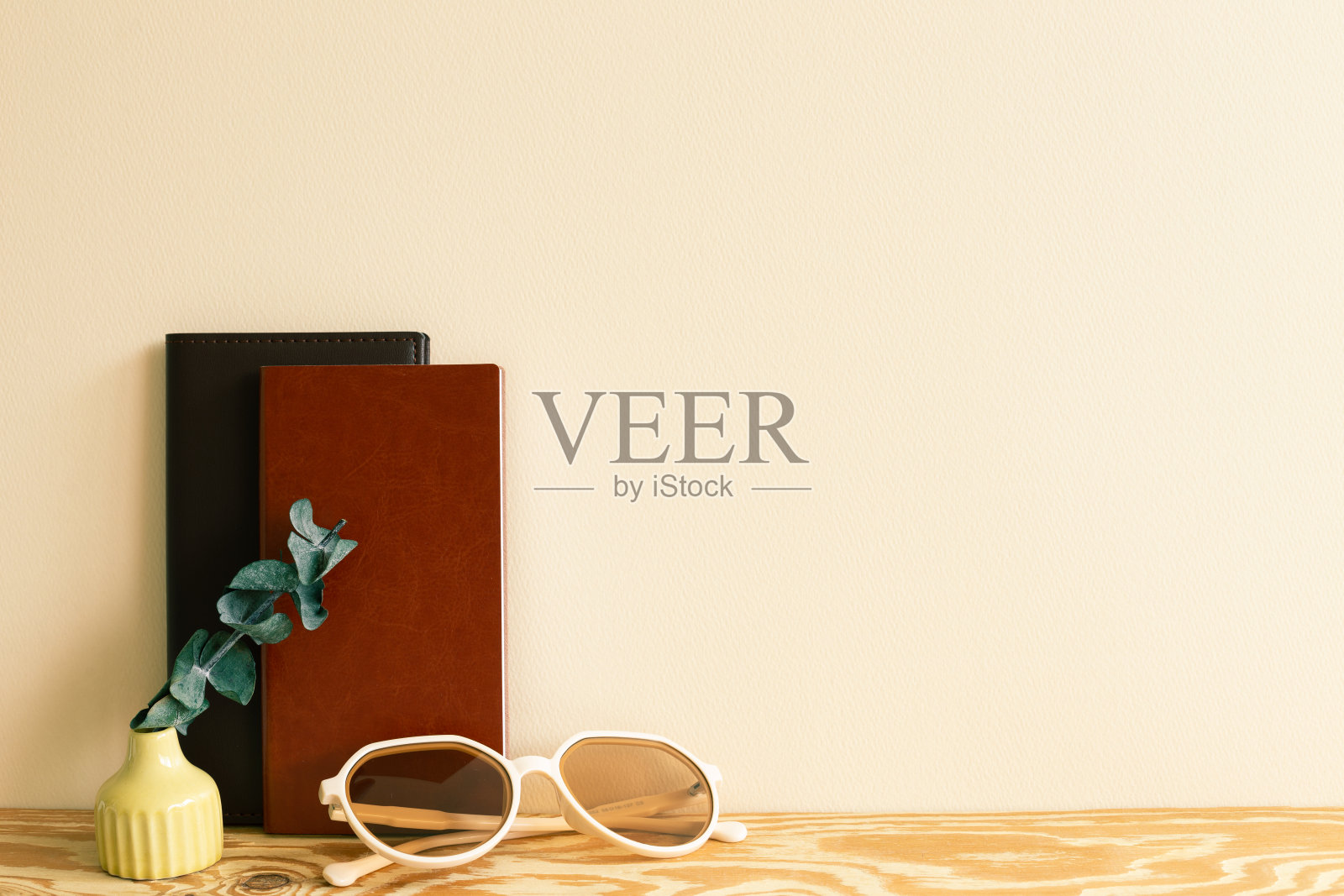 笔记本,眼镜,木桌上的桉树。米色背景墙。工作空间照片摄影图片