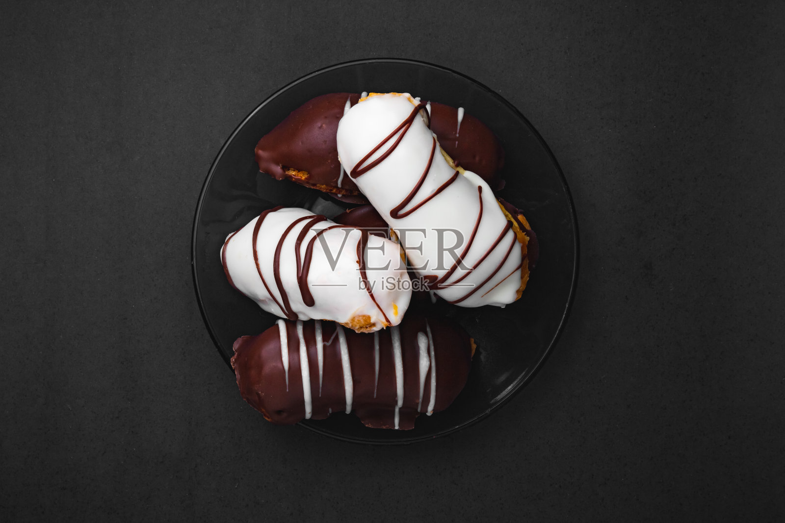 巧克力脆饼。传统的巴西éclair,黑色背景上填充巧克力或牛奶。照片摄影图片