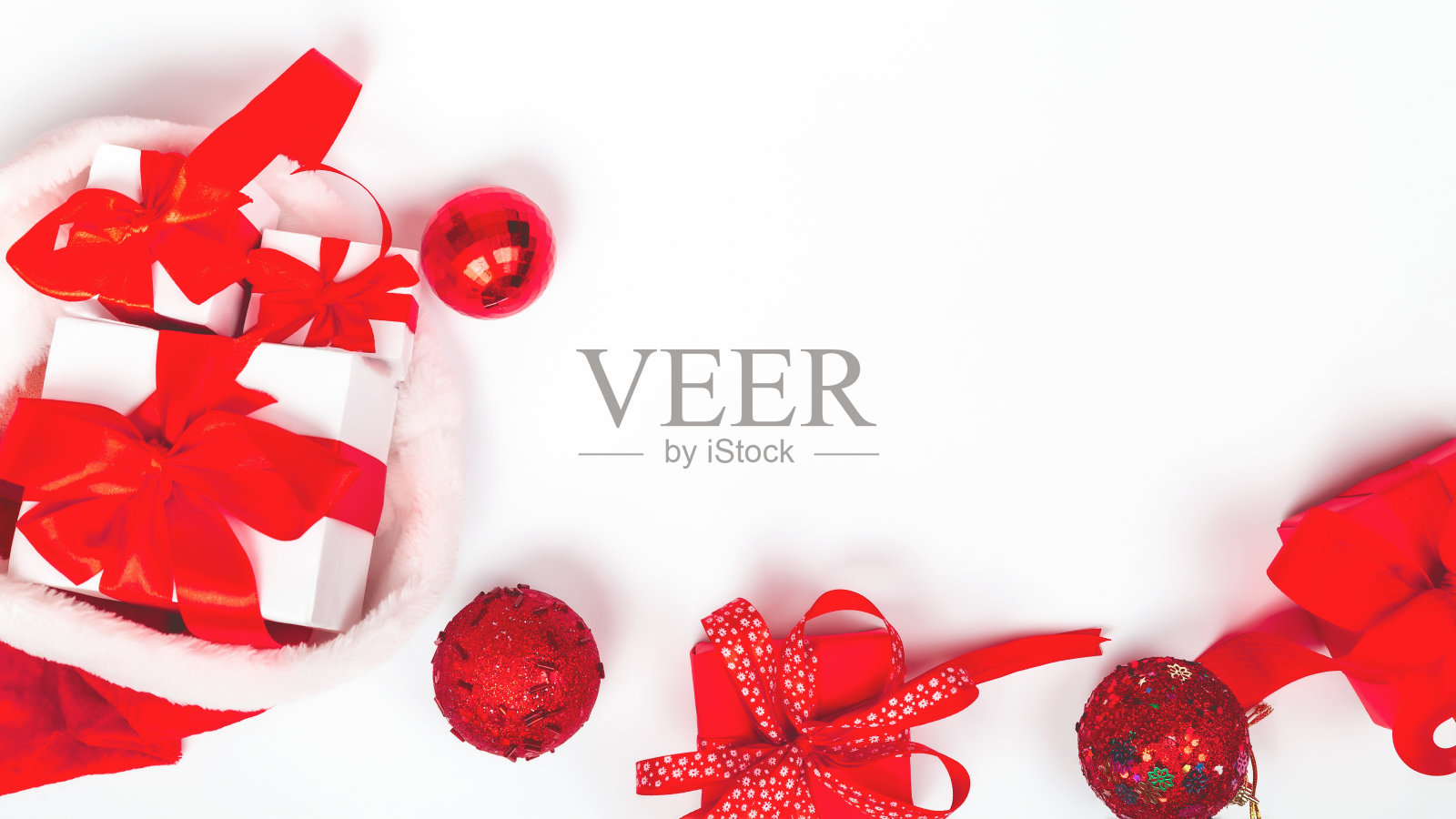 圣诞老人的帽子里装满了圣诞盒子里的礼物。购物背景与礼品盒在绿色和红色。空间的文本照片摄影图片