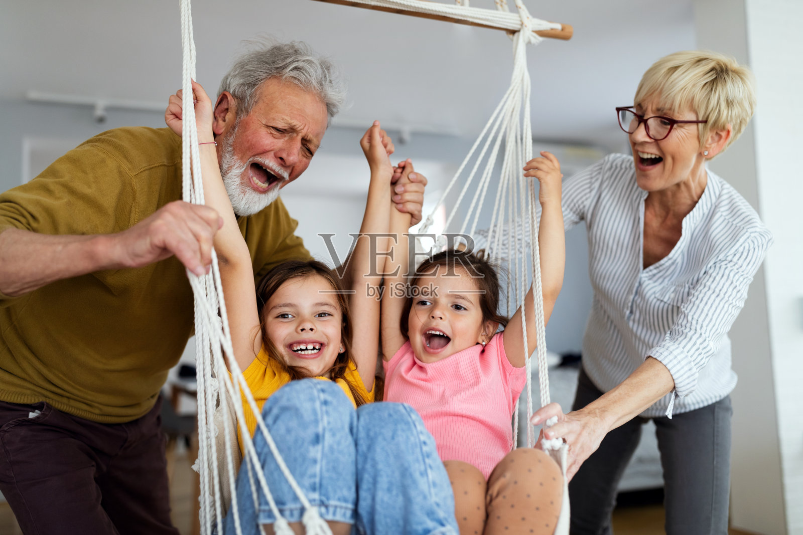 快乐的祖父母在家里和孩子们玩得开心照片摄影图片