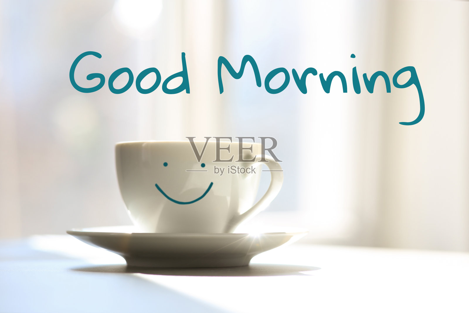 早上好。美味的咖啡杯和笑脸放在阳光下的桌子上照片摄影图片