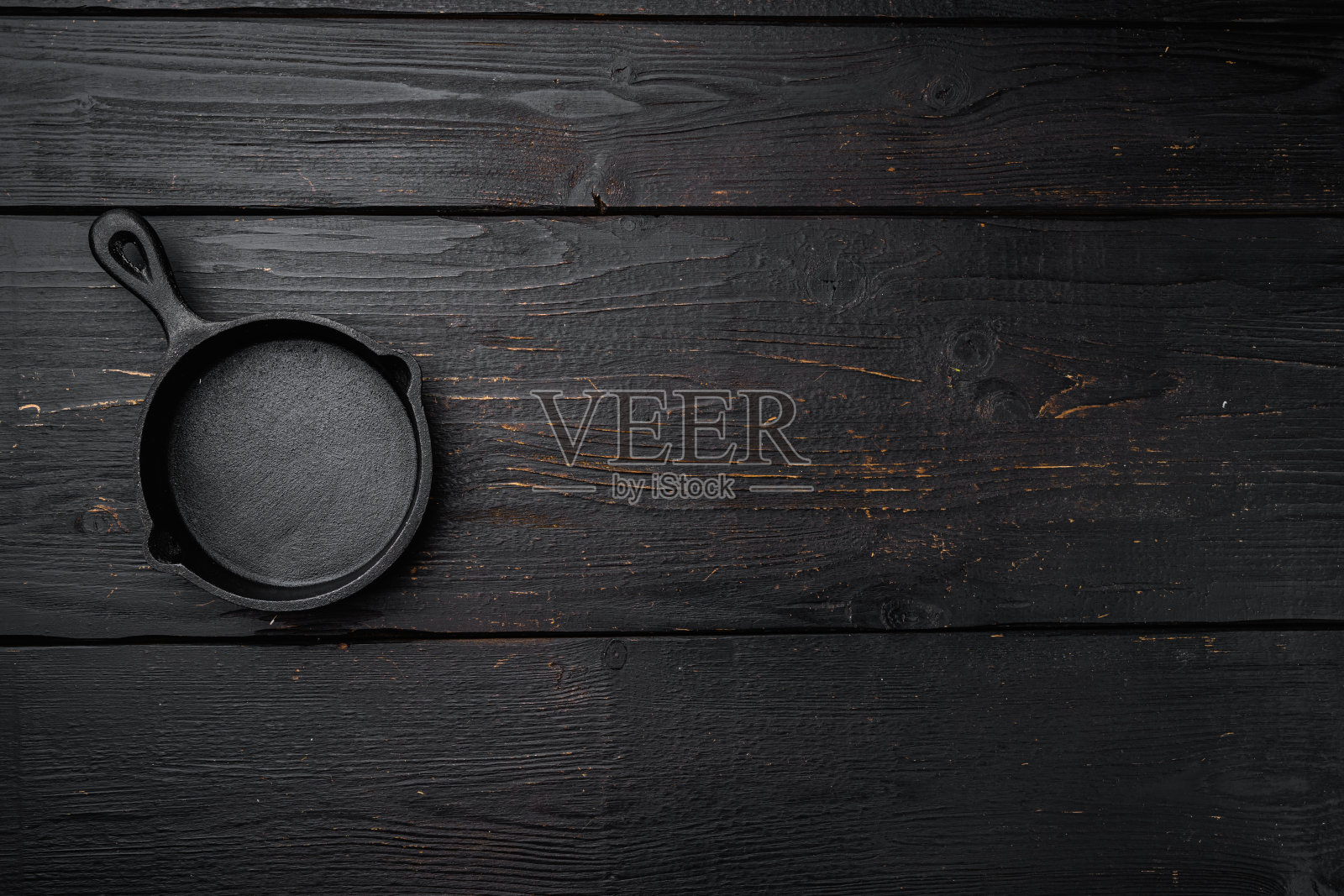 老式铸铁煎锅与文本或食物的复制空间,文本或食物的复制空间,俯视图平铺,在黑色木桌背景照片摄影图片