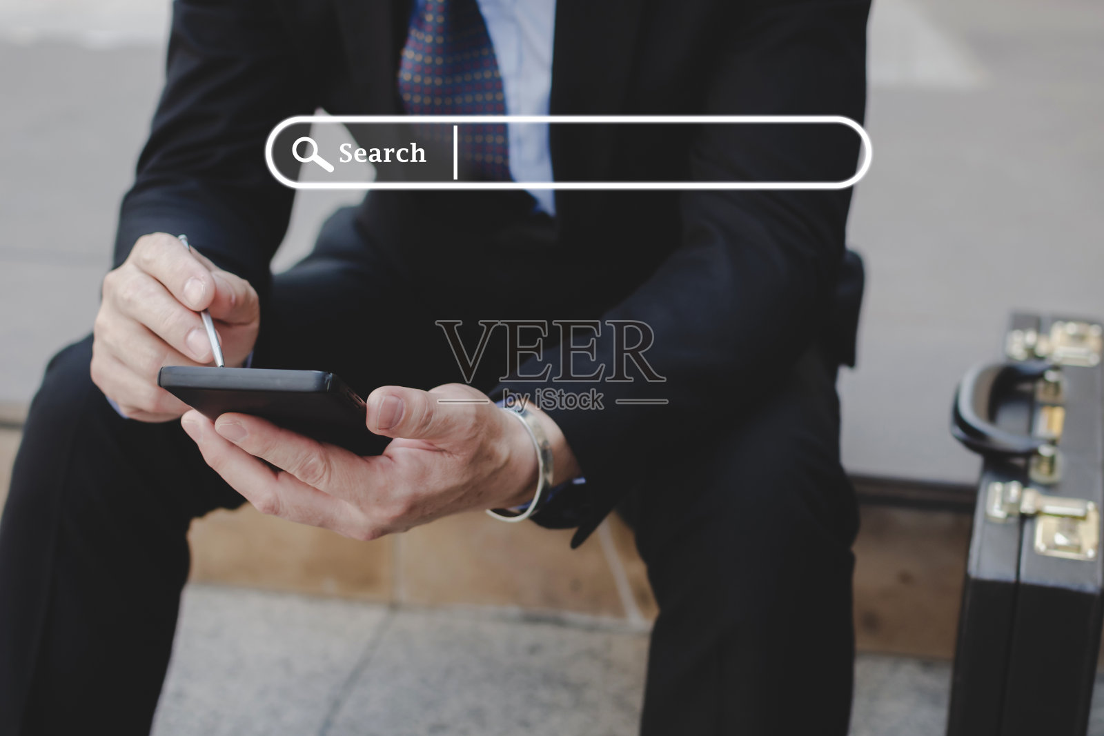 商人投资者在西装使用手写笔在手机上与搜索栏图形,搜索网站,社交网络,互联网在线,工作搜索引擎,商业金融,数字技术概念照片摄影图片