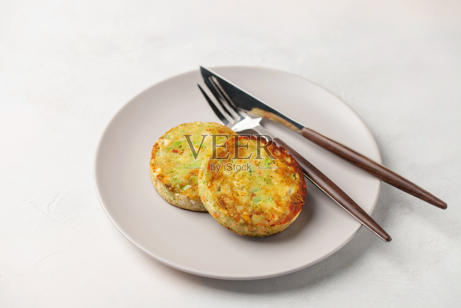 蔬菜素食花椰菜,土豆和花椰菜肉片在一个盘子上的桌子。饮食营养照片摄影图片