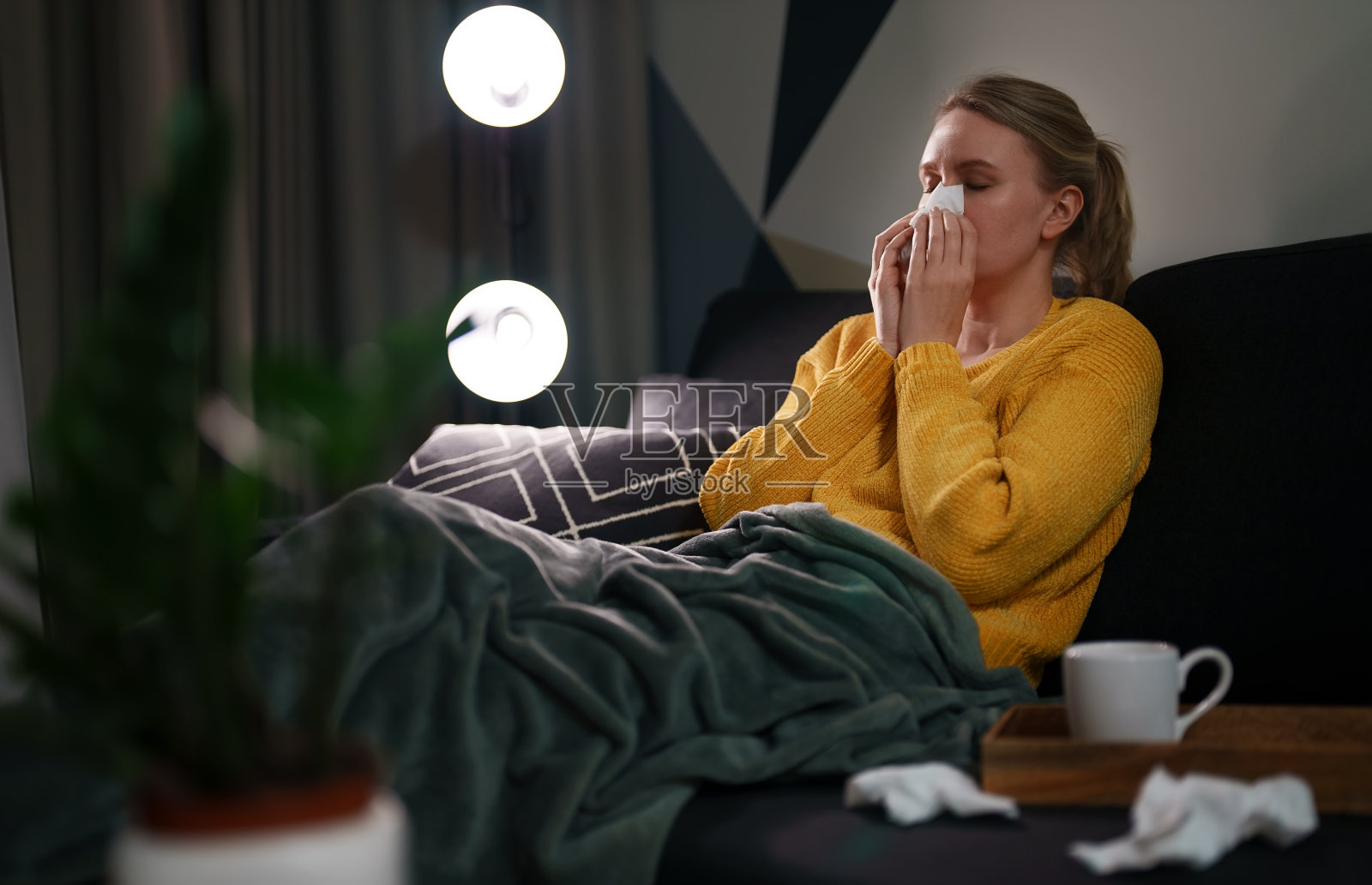 生病的女人躺在客厅的床上。照片摄影图片