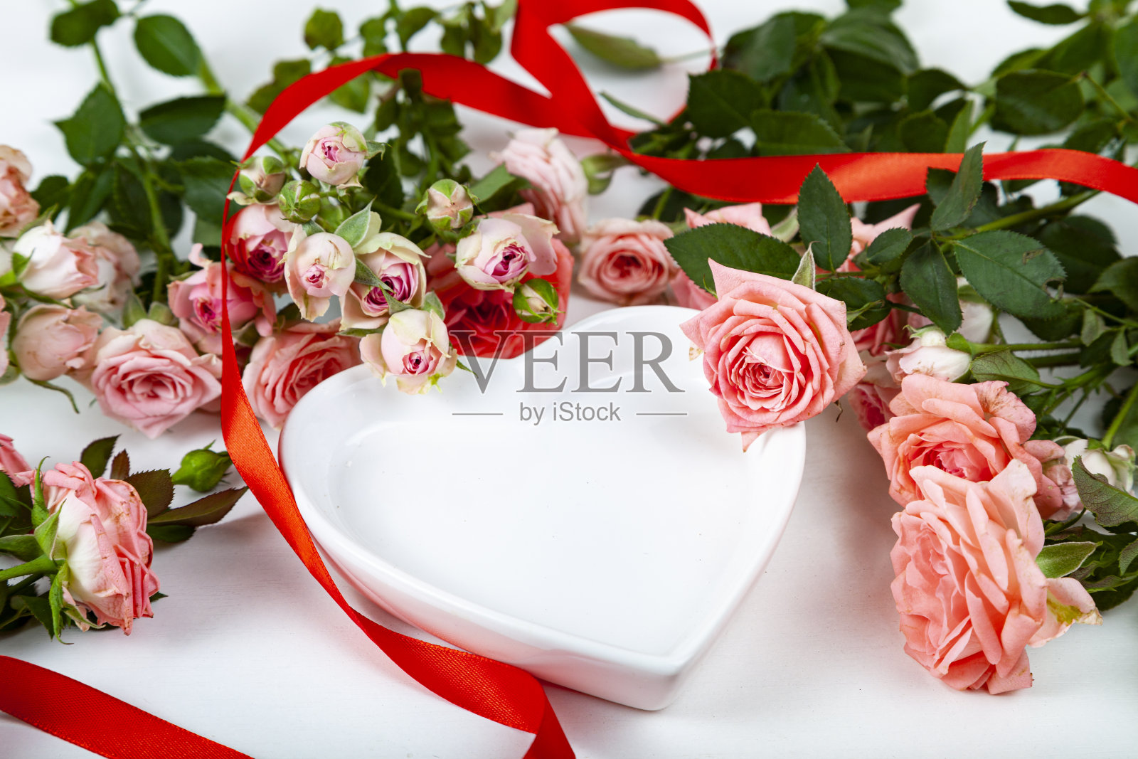 一束粉红色的玫瑰和一个心形的盘子照片摄影图片