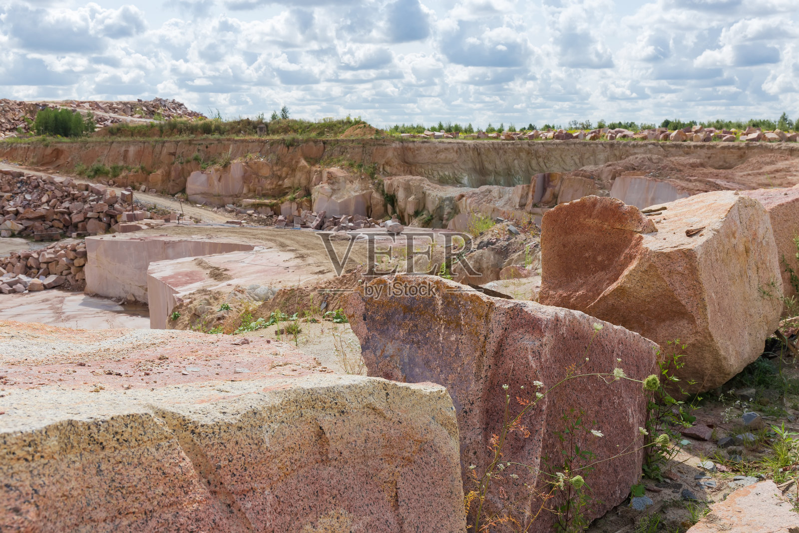 采石场附近边缘被撕裂的大块红色花岗岩照片摄影图片