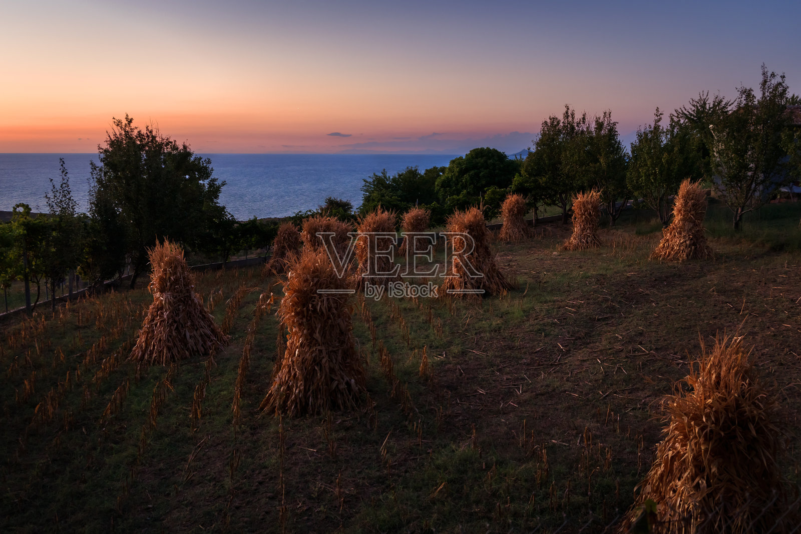 黄昏的干草堆在海村与海日落的背景广场杰内利特照片摄影图片