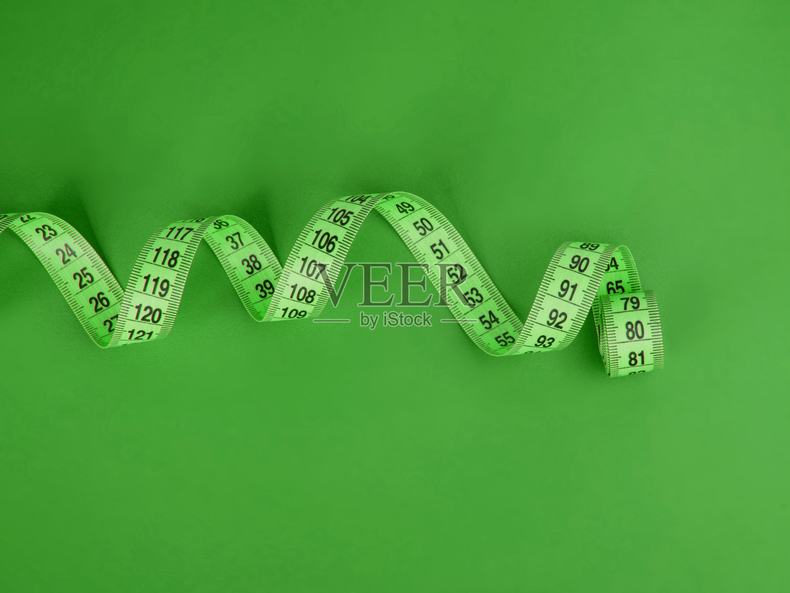 在绿色背景上测量绿色卷尺照片摄影图片