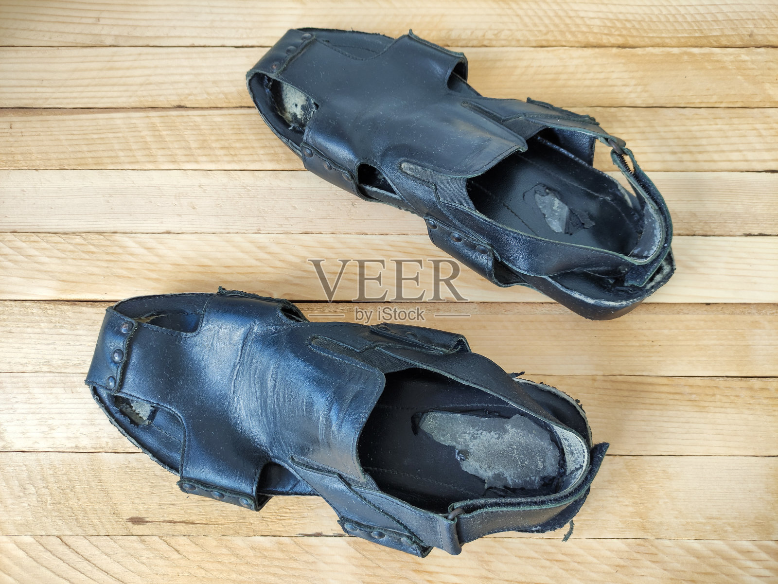 破旧的黑人男子皮革凉鞋在木制背景,俯视图照片摄影图片