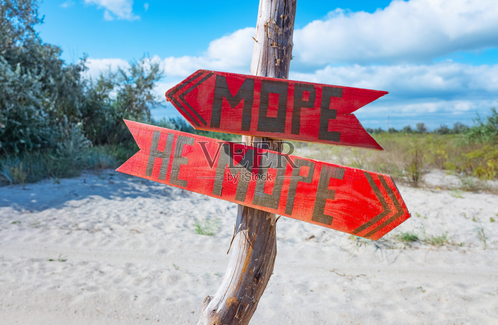 西里尔字母自制的红色木制方向箭头“海和不是海”。照片摄影图片