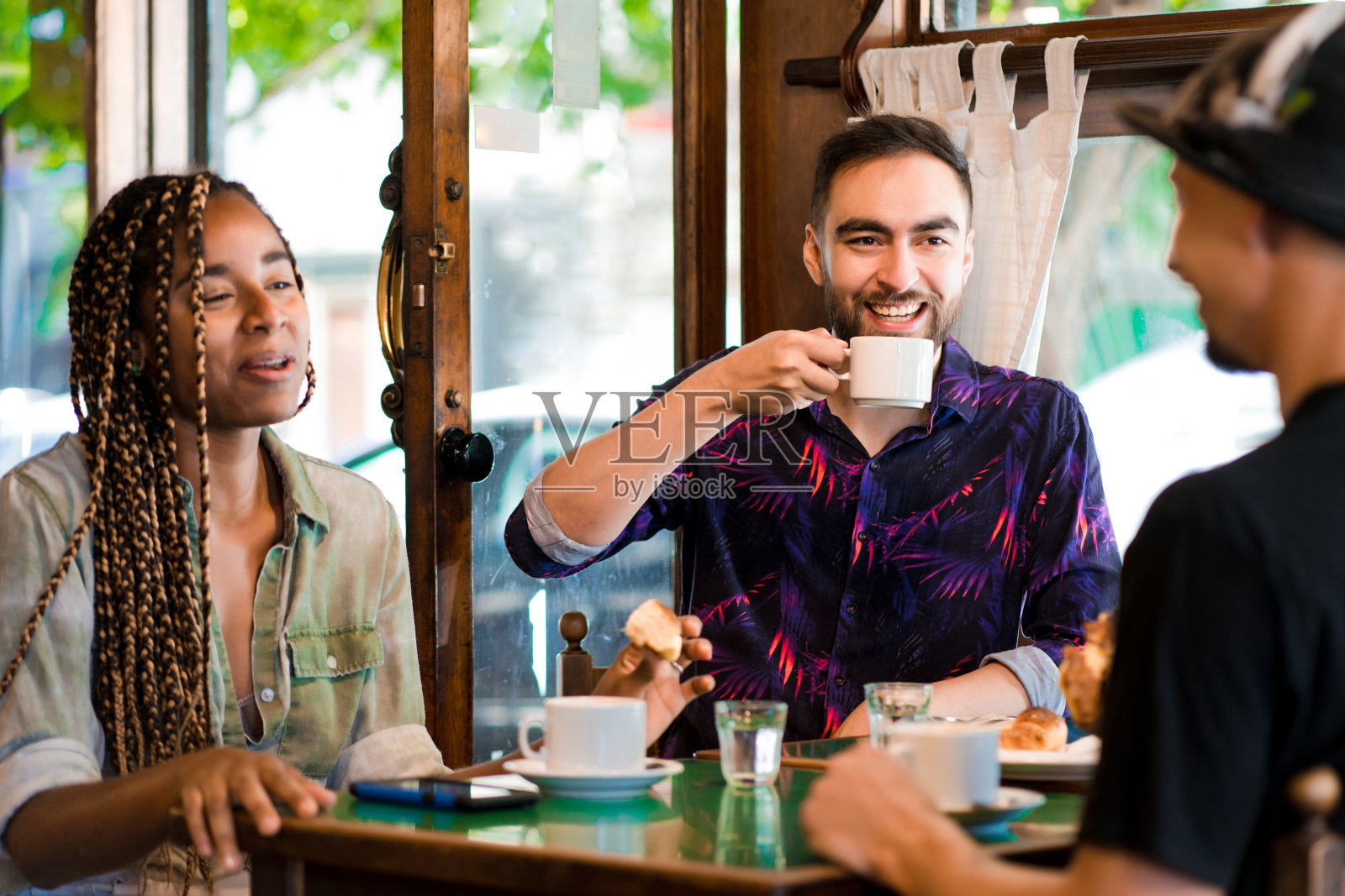 朋友们喜欢在咖啡店里一起喝咖啡。照片摄影图片