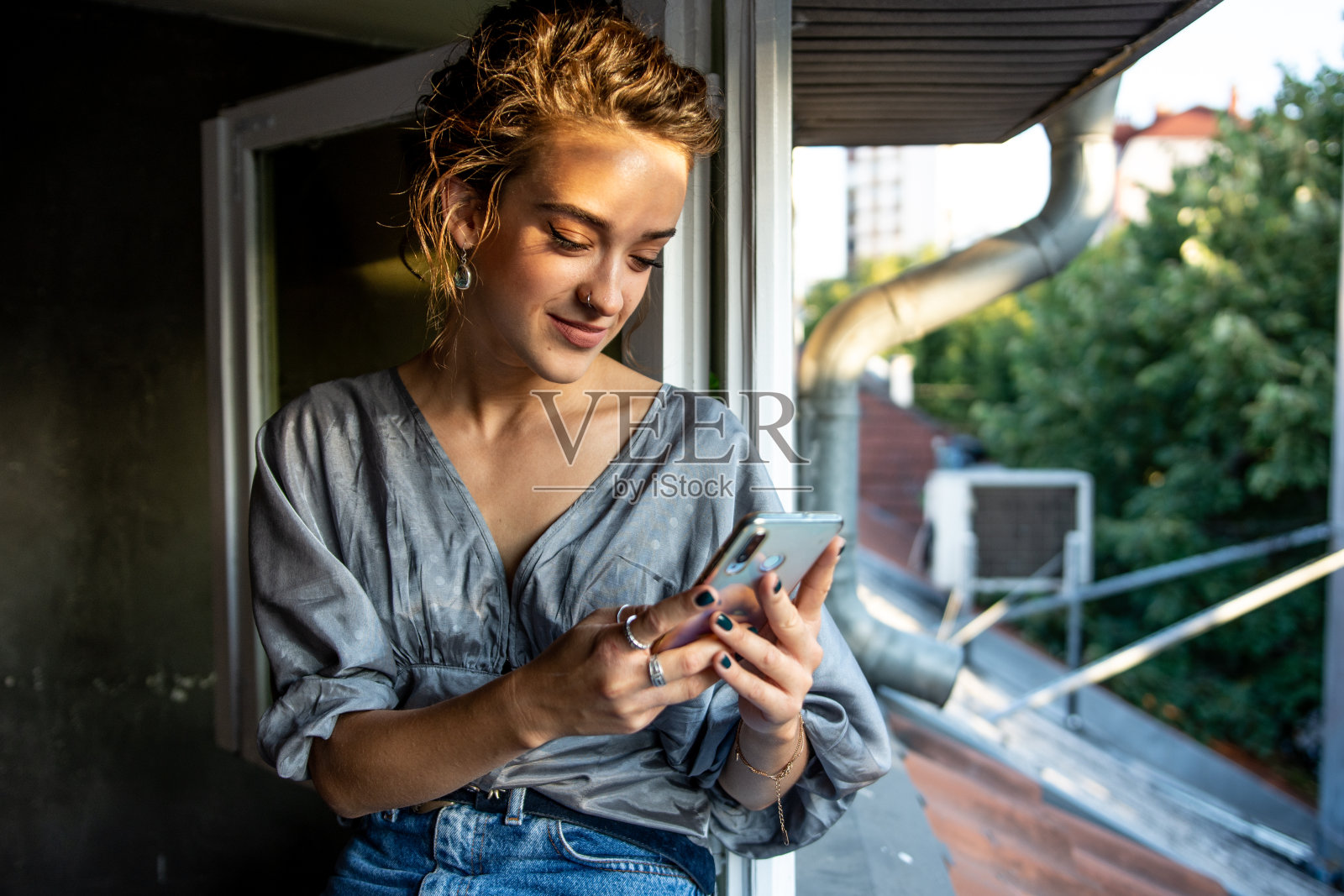 年轻漂亮的女人在家用智能手机照片摄影图片