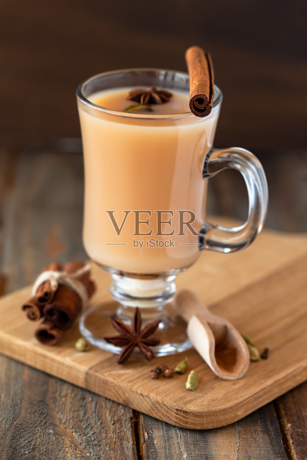 传统的印度自制马沙拉茶配料。肉桂,豆蔻,茴香,红茶。秋冬热饮。芳香疗法,温馨的居家氛围。木制背景。照片摄影图片