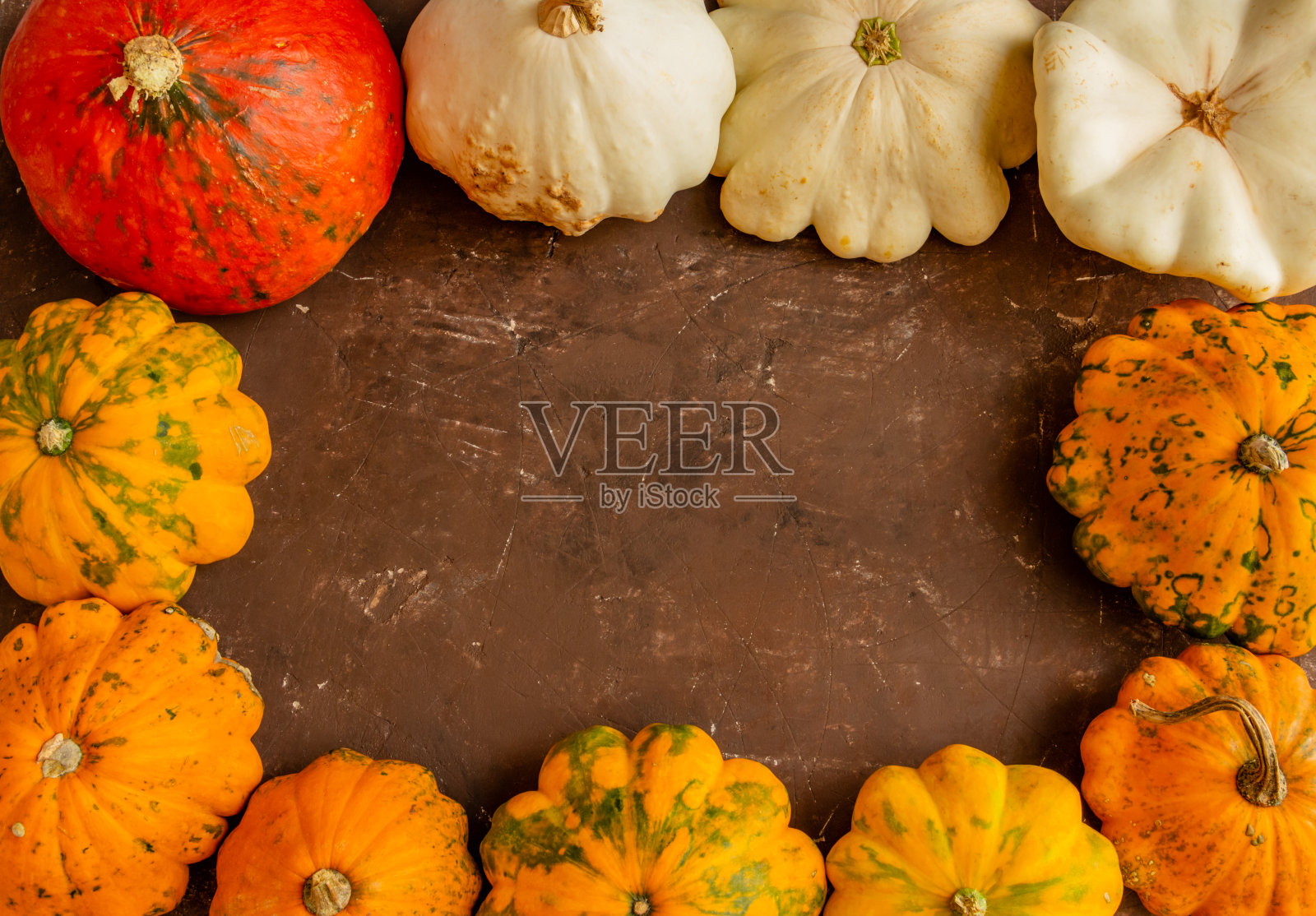 秋天的构图,棕色背景上的南瓜,感恩节或万圣节的概念。平铺,复制空间,俯视图照片摄影图片