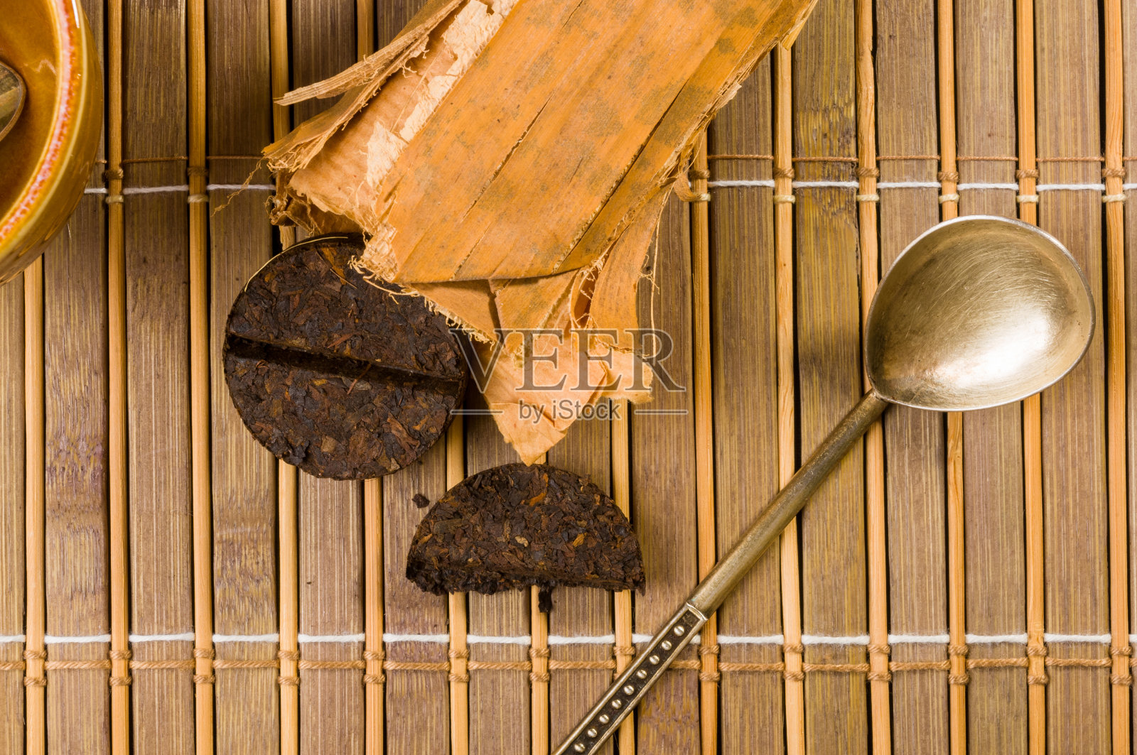 中国压普洱茶在竹叶包装和茶叶配件在竹席上,特写,宏观照片摄影图片