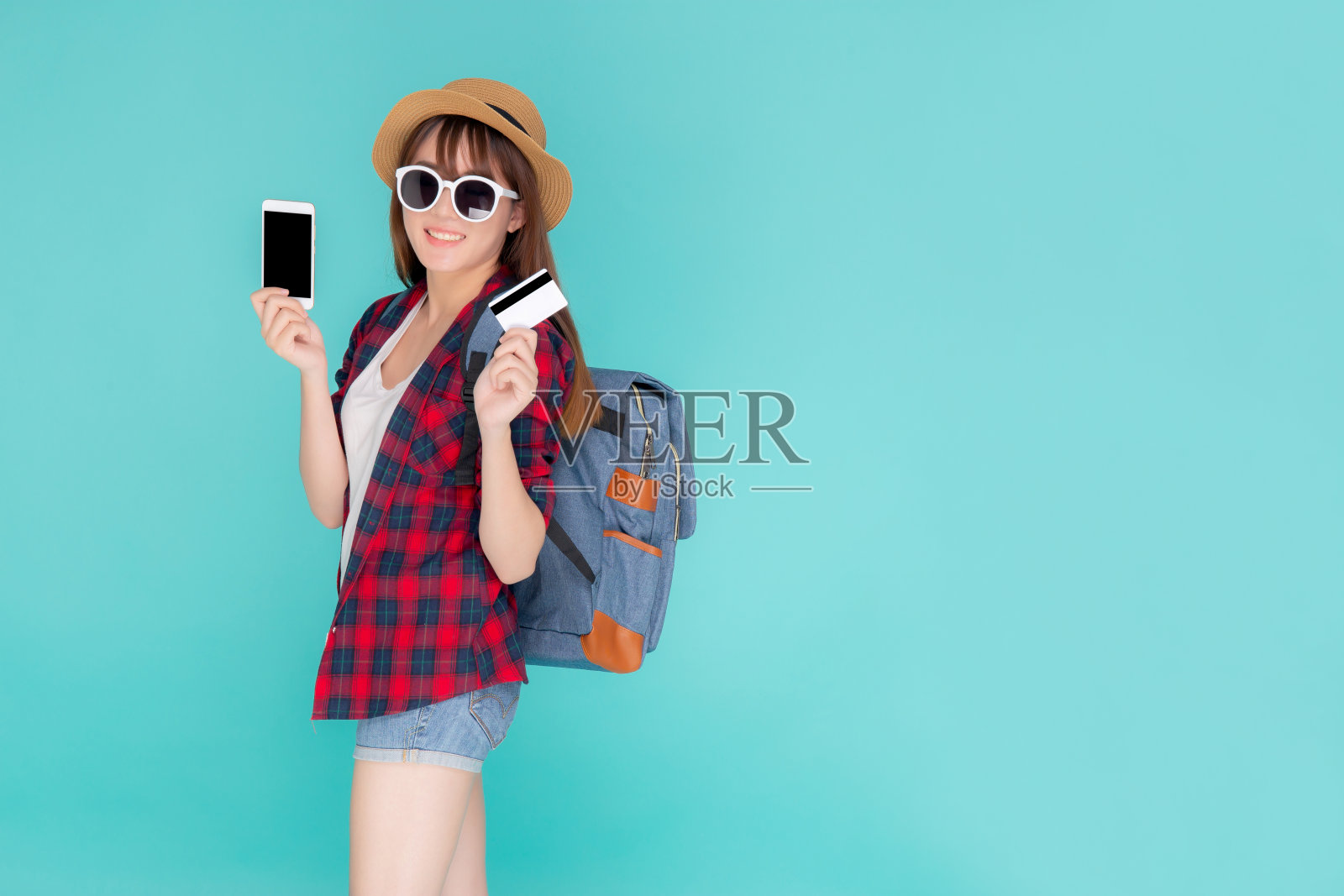 美女写真年轻的亚洲女性穿着旅行夏装手持信用卡和智能手机在夏天,亚洲女孩支付预订在网上与app在假期。照片摄影图片