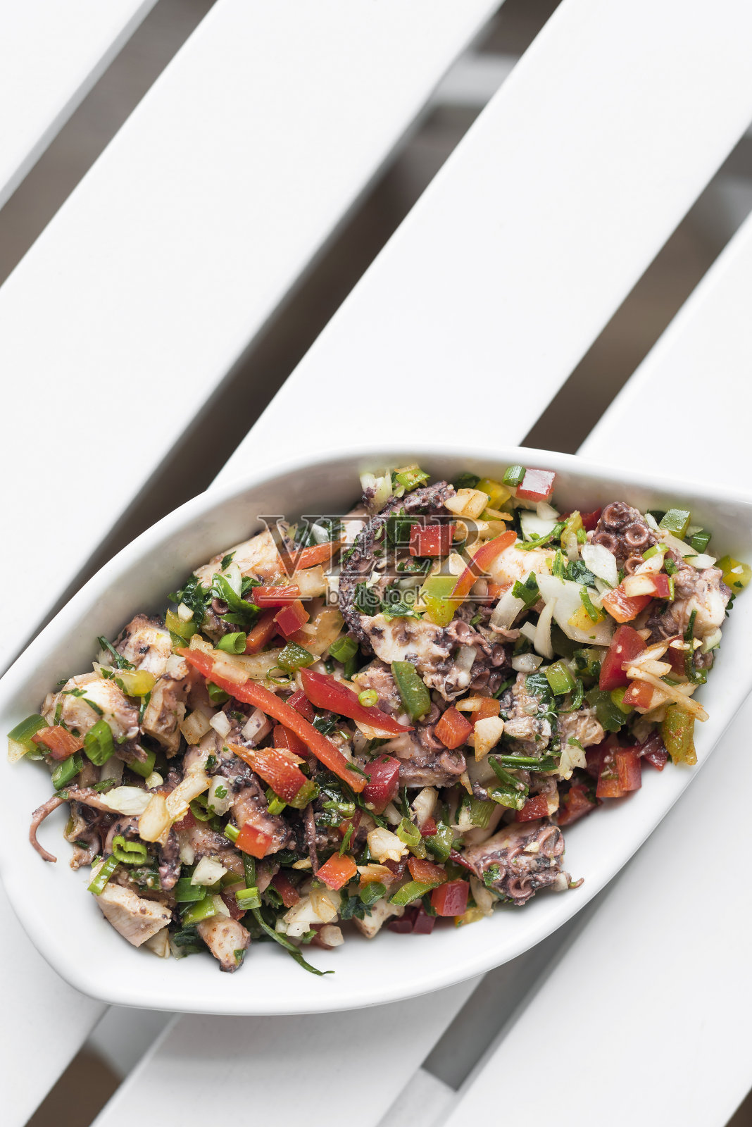 在希腊雅典,传统的希腊Ktapodi章鱼沙拉碗放在餐厅的白色餐桌上照片摄影图片