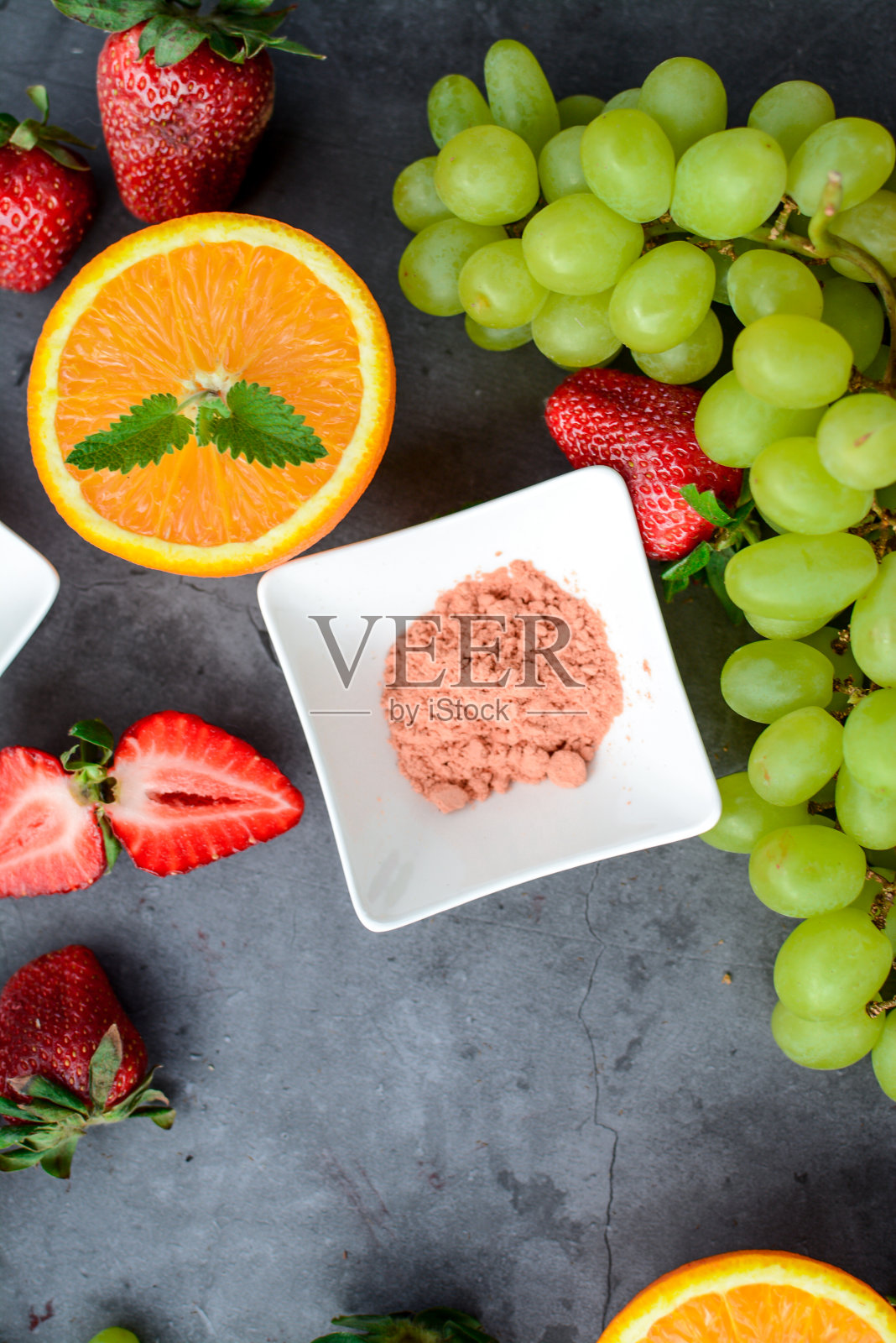 深色石桌上放着各种水果和浆果,厨房里放着素食照片摄影图片