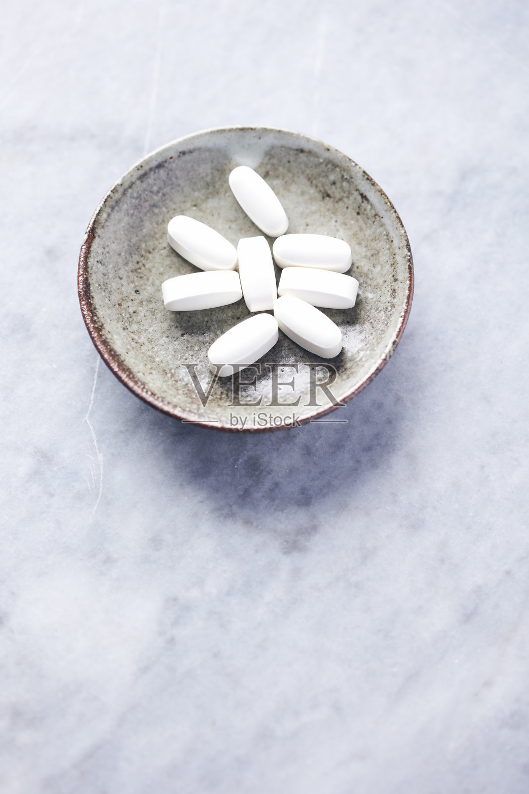 赖氨酸平板电脑。健康膳食补充的概念神经系统的支持。明亮的石头背景。关闭了。副本的空间。照片摄影图片